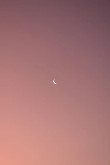 A delicate watercolor illustration of a moon and stars blending softly into a pastel background.