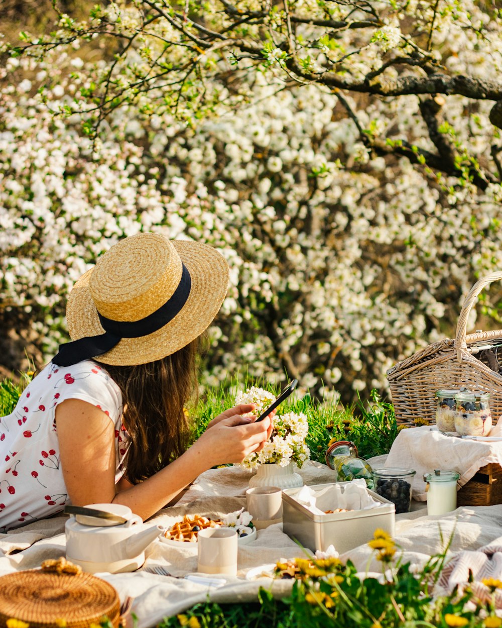 a person sitting at a table with food and a tree in the background