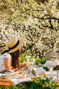 a woman sitting at a table with food and flowers