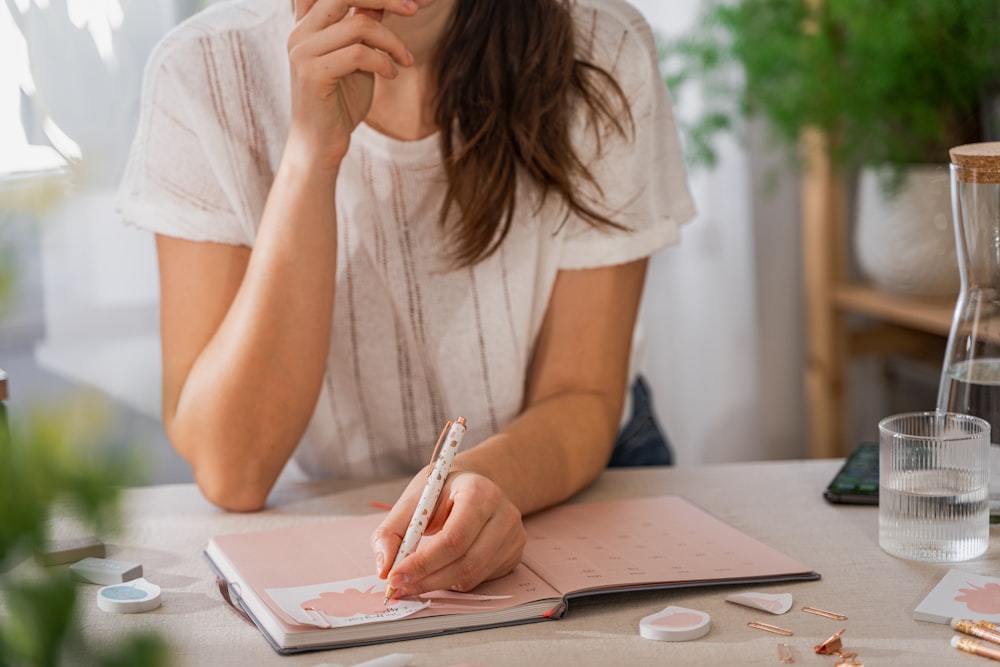 a woman writing on a piece of paper