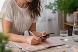 a woman writing on a piece of paper