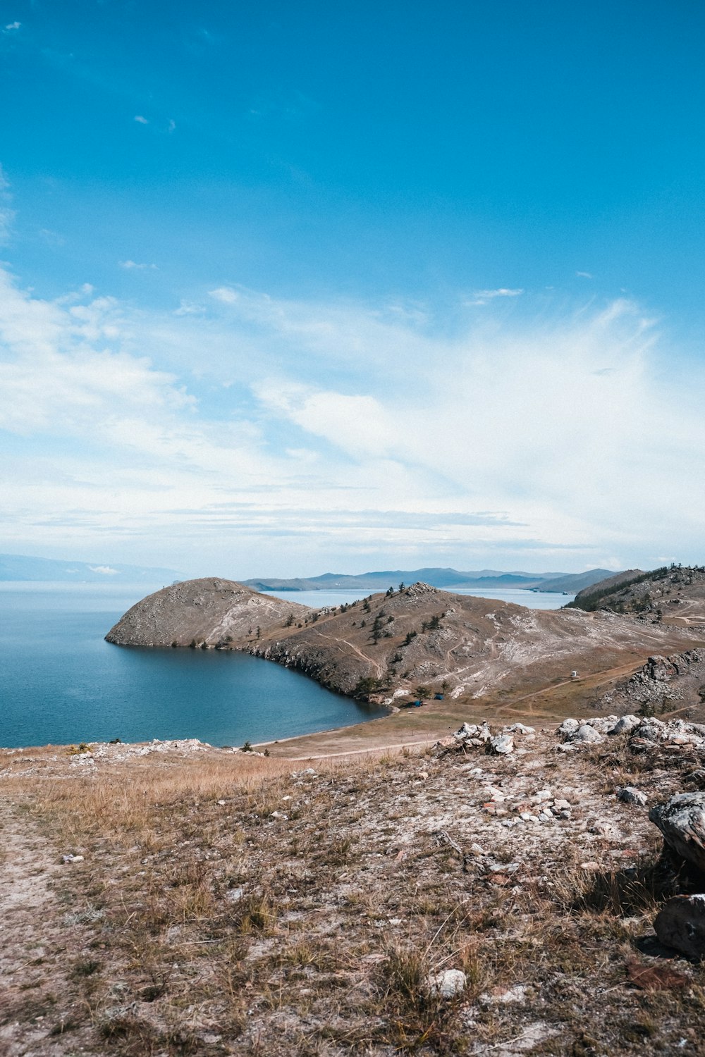 a rocky beach with a body of water in the background