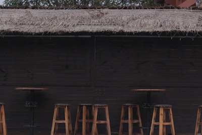 Rustic wooden bar setup with a single bartender serving drinks under warm string lights.