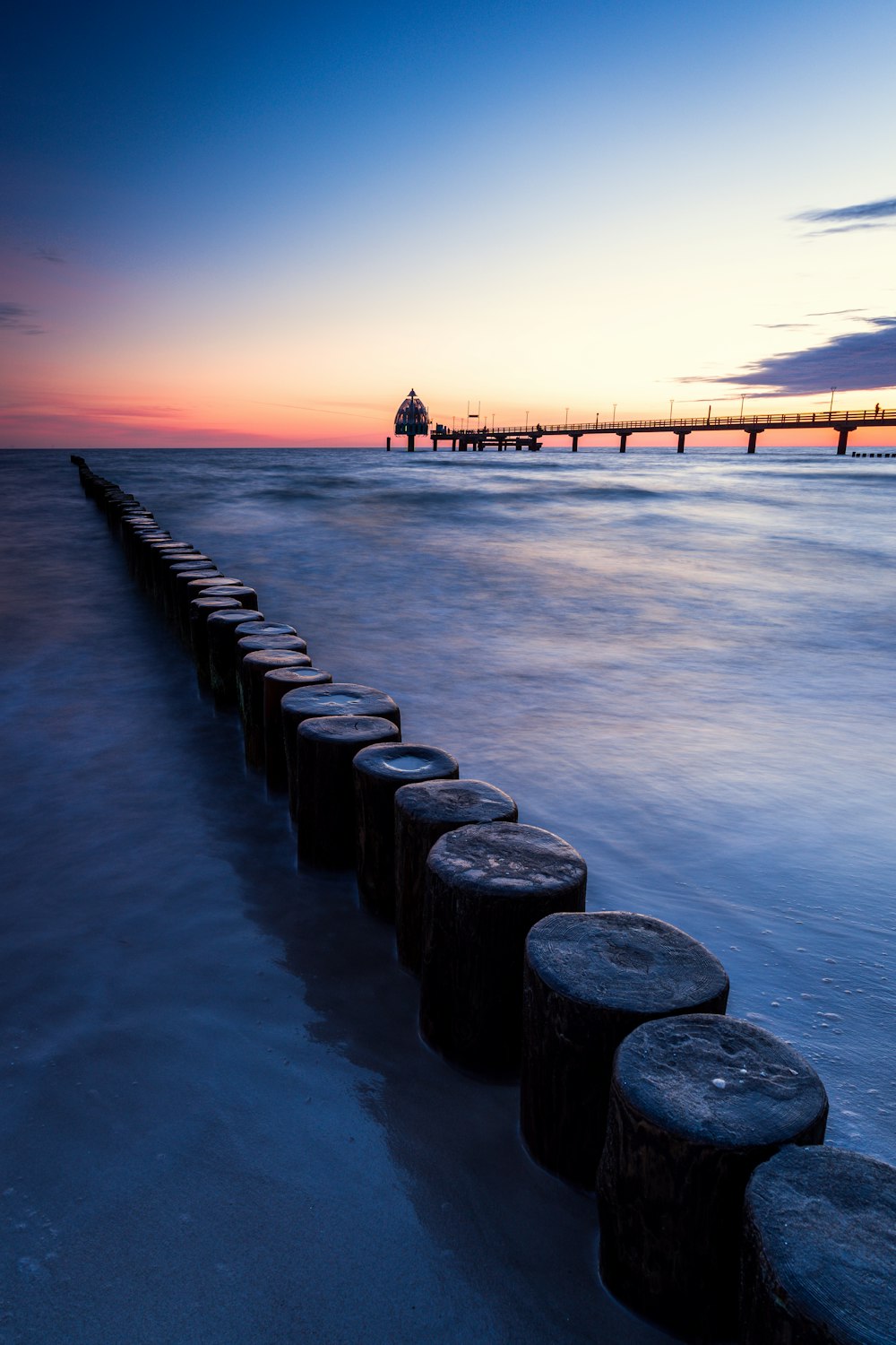 a dock with rocks on it and a boat in the water