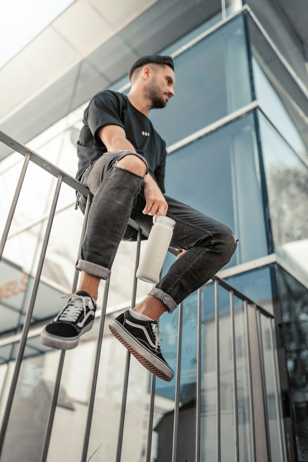 a man sitting on a glass wall