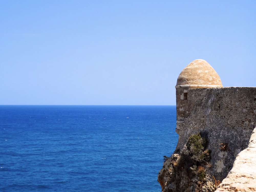 a stone structure on a cliff overlooking the ocean