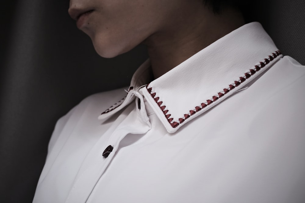 a person wearing a white shirt with a red ribbon