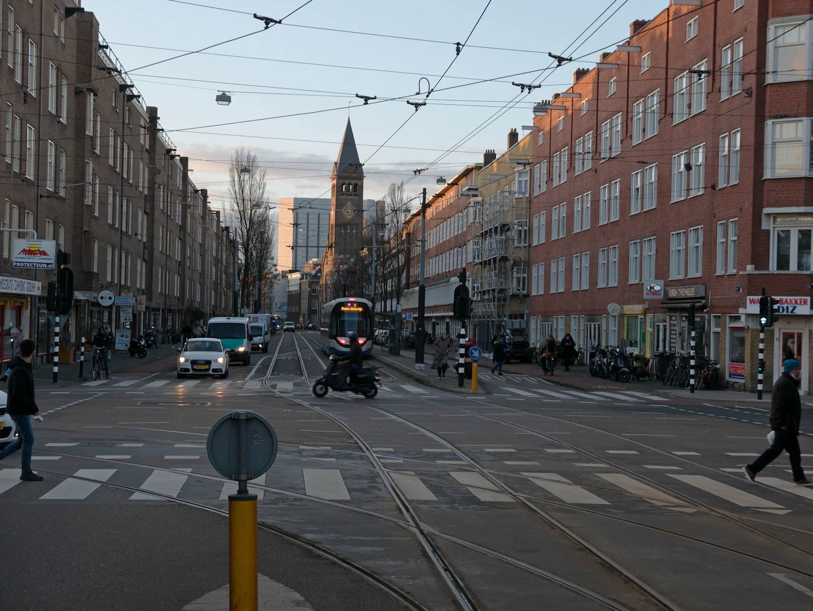 Cars, trams and cyclists meet at an Amsterdam intersection