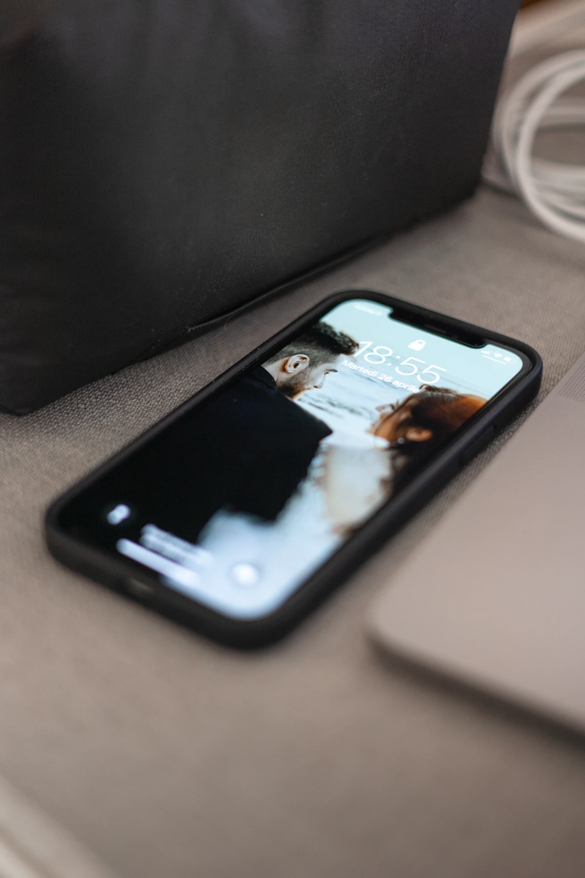 Smartphone mit Sperrbildschirm liegt auf einem Sofa
