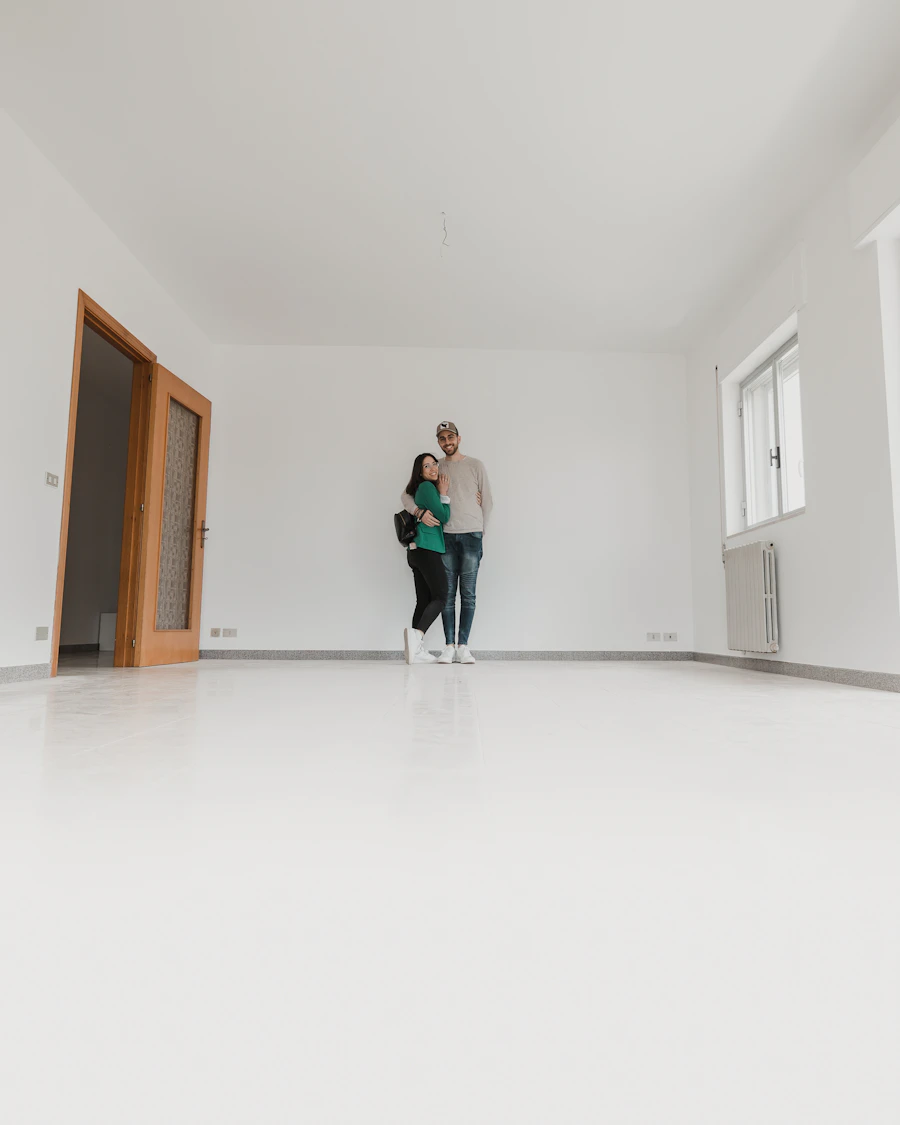 Casal abraçado num apartamento vazio e claro