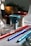 A collection of colorful hookah components arranged on a surface, including a decorative glass base, ceramic bowls in various colors, and metal stems with a shiny finish.