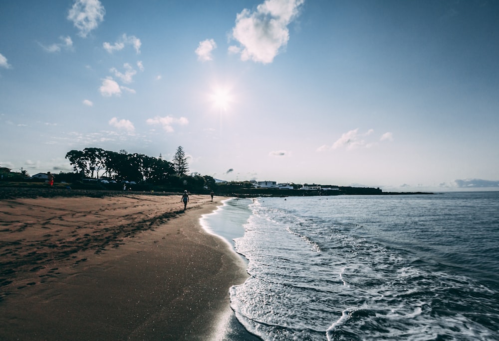 a beach with people walking on it