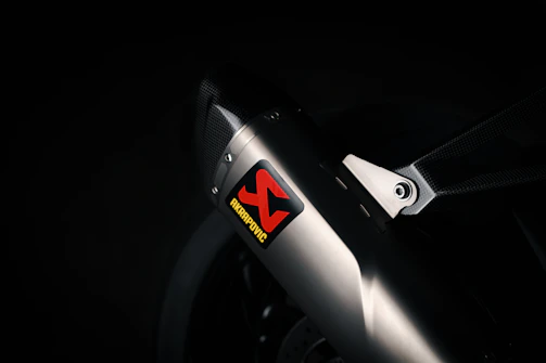 Dynamic shot of a custom exhaust system being fitted, with sparks flying in a professional garage.