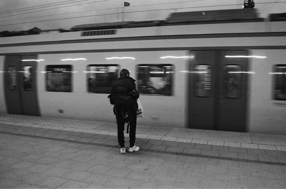 a man and woman standing in front of a train