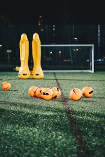 a group of yellow and orange balls on a green field