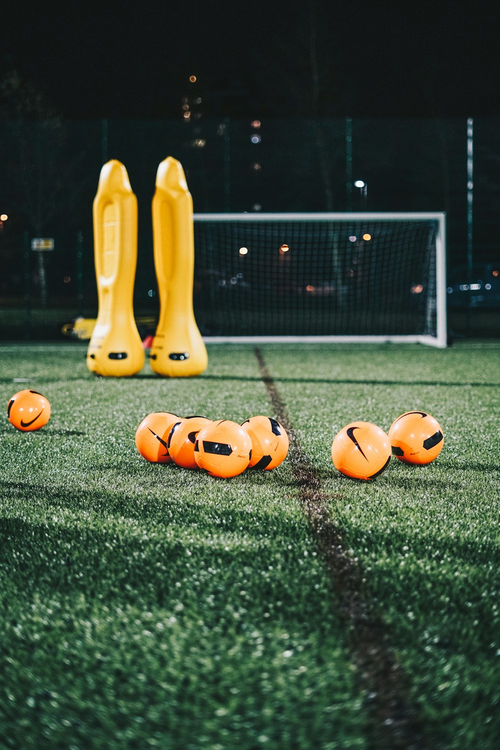 a group of yellow and orange balls on a green field