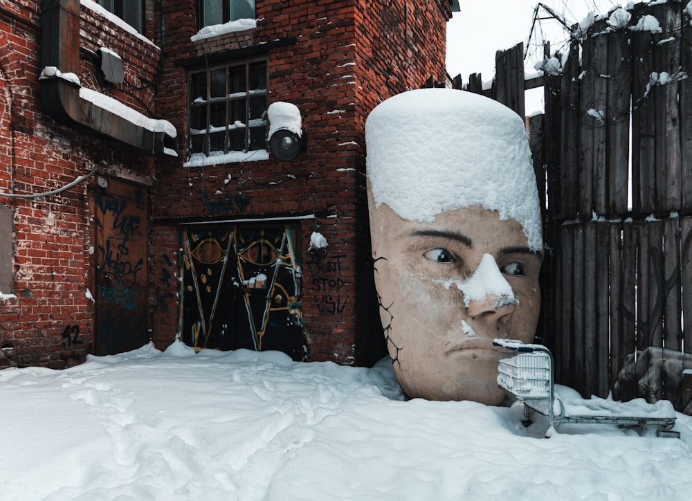 a statue of a person with a cigarette in the mouth in the snow