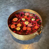 The Holy Ganga Reiki manual displayed alongside a small brass bowl filled with sacred water and flower petals.