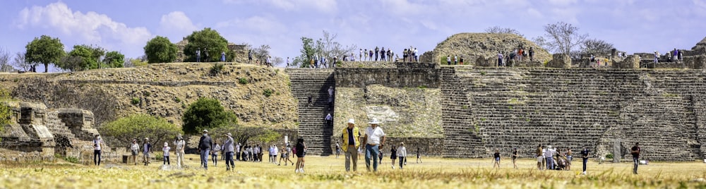 a group of people standing around a stone wall