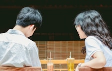 a man and woman sitting at a table with drinks