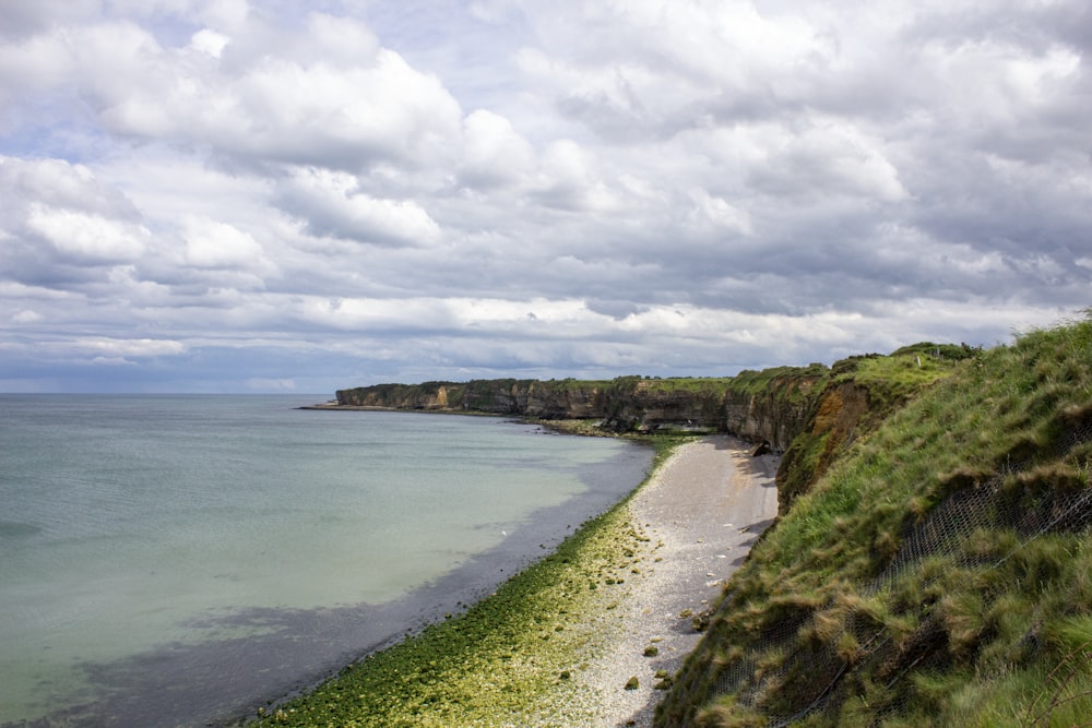 a beach with a body of water and land with trees on it