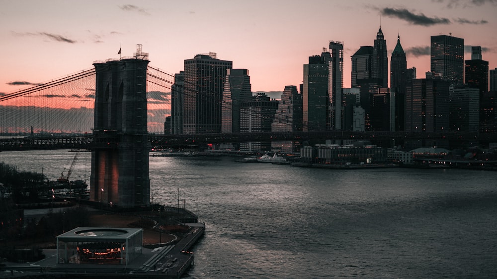 a bridge over a river with a city in the background