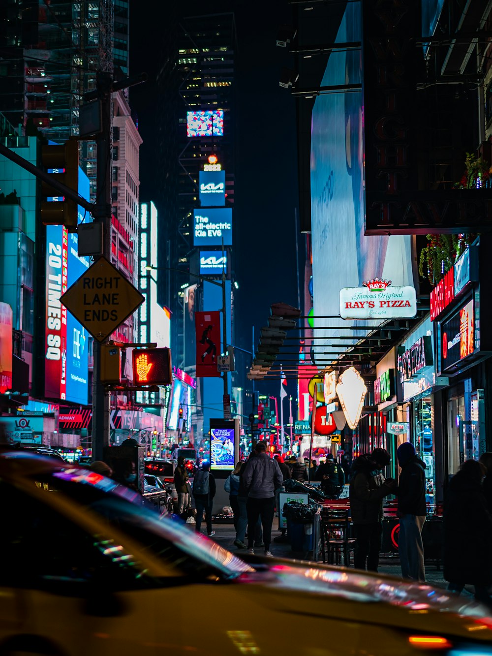 a busy city street with Times Square in the background