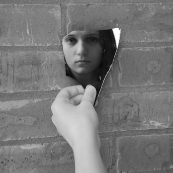 a woman leaning against a brick wall