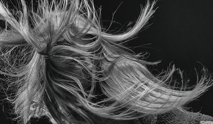 Curly texture wig styled elegantly on a model, capturing movement and shine in natural light.