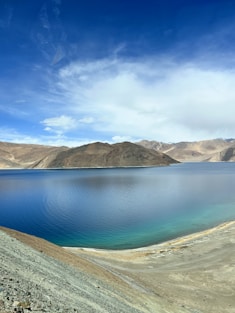a body of water with hills in the background