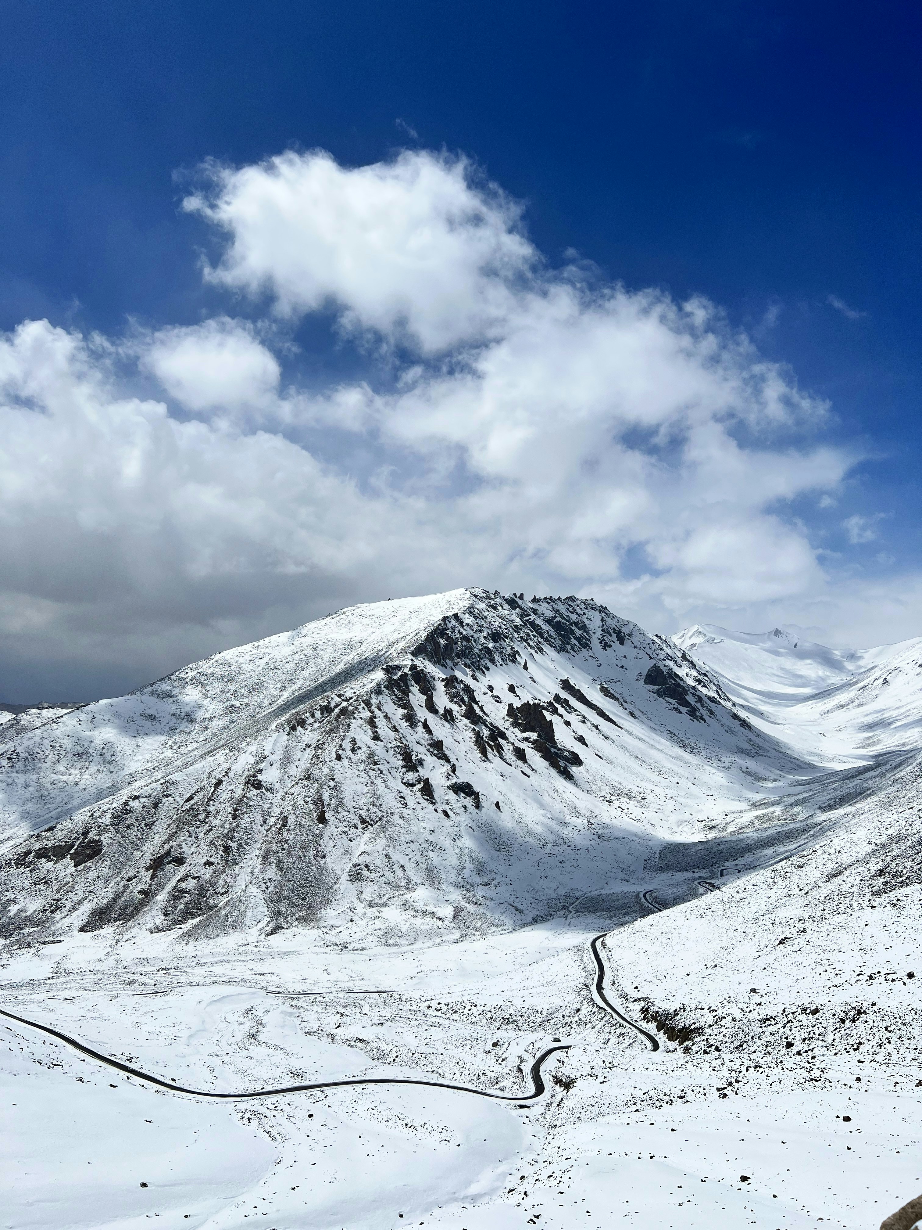a snowy mountain with clouds