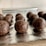 Several chocolate energy balls, textured with visible bits of oats or nuts, arranged on a sheet of aluminum foil with a light background.