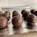 Several chocolate energy balls, textured with visible bits of oats or nuts, arranged on a sheet of aluminum foil with a light background.