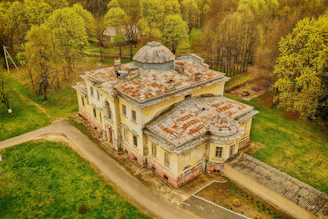 An old photograph of the ancestral zamindar mansion in Bangarhatta village, surrounded by lush greenery.