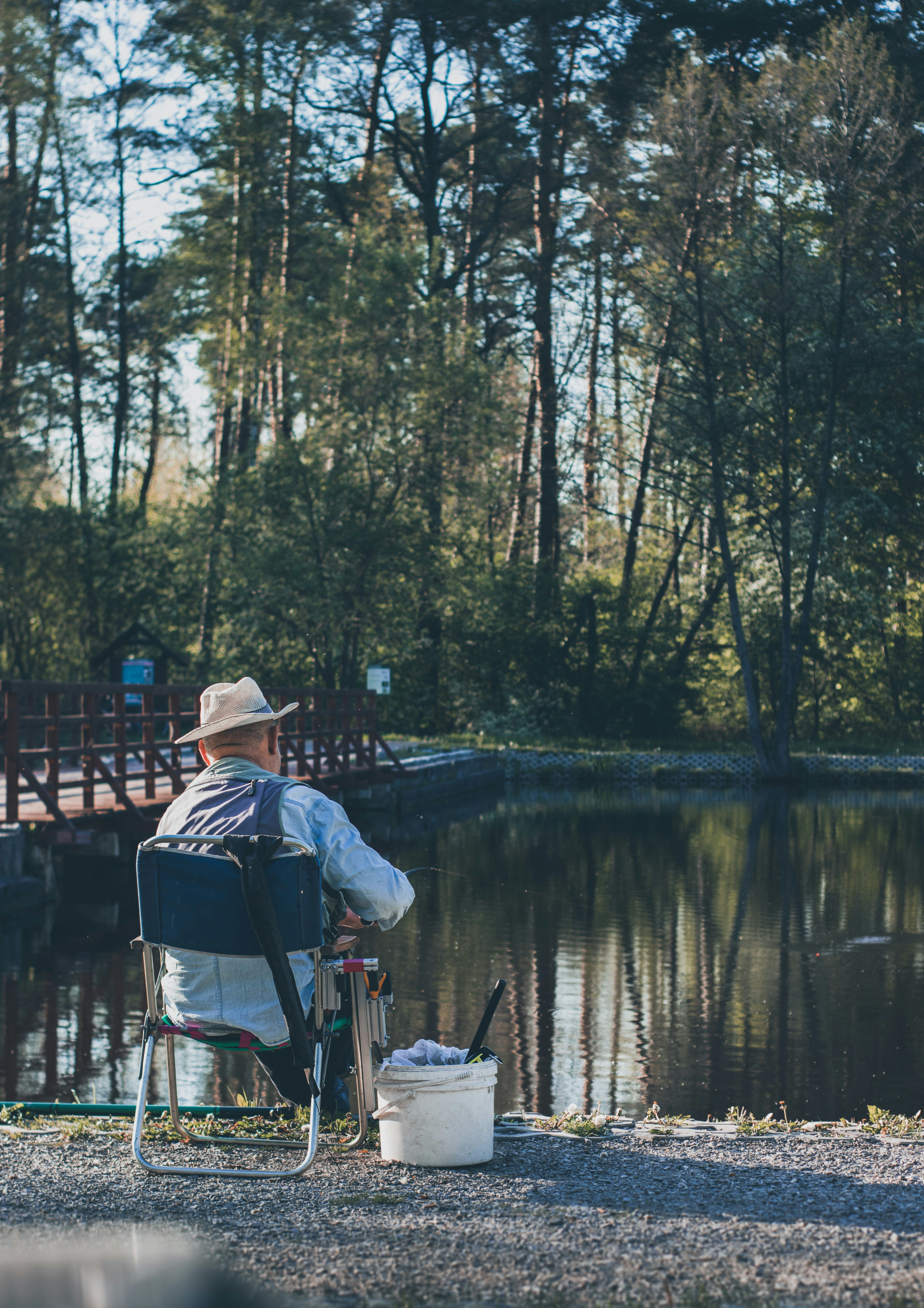 a person sitting on a chair by a lake