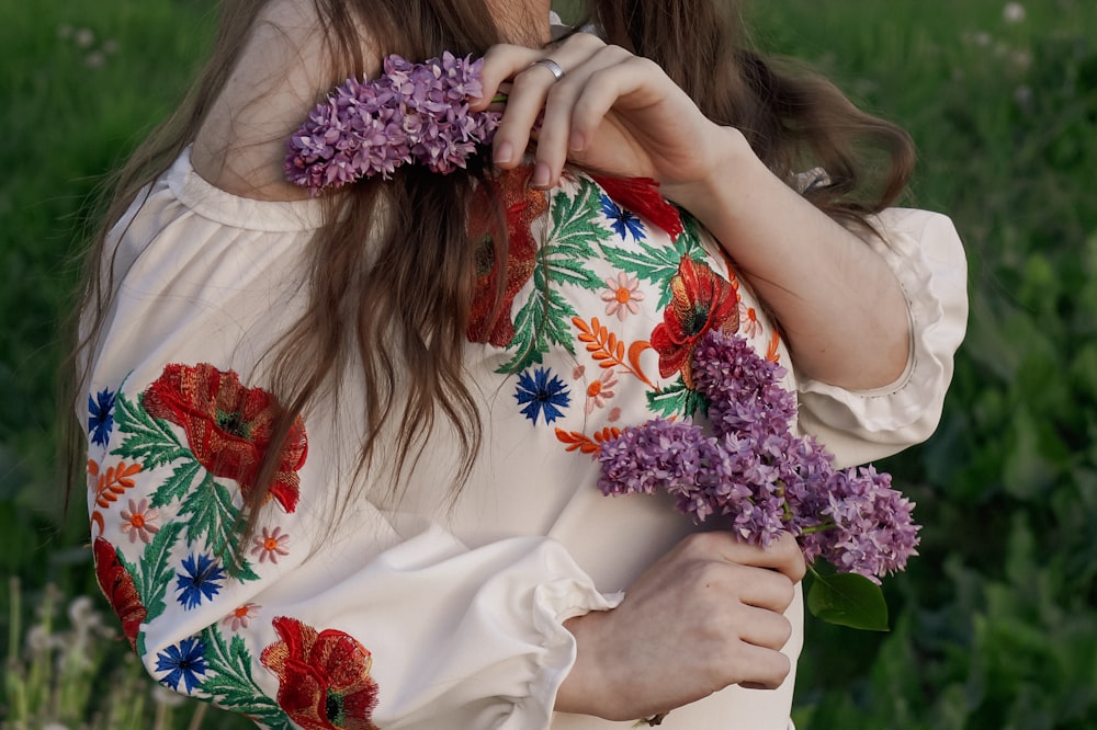 a person wearing a white dress and holding flowers