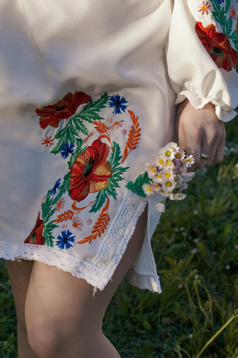 a person wearing a white dress with flowers on it