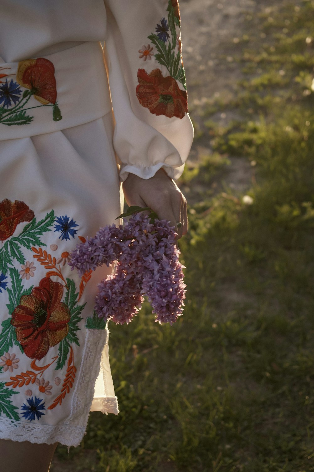 a person wearing a white dress with flowers on it