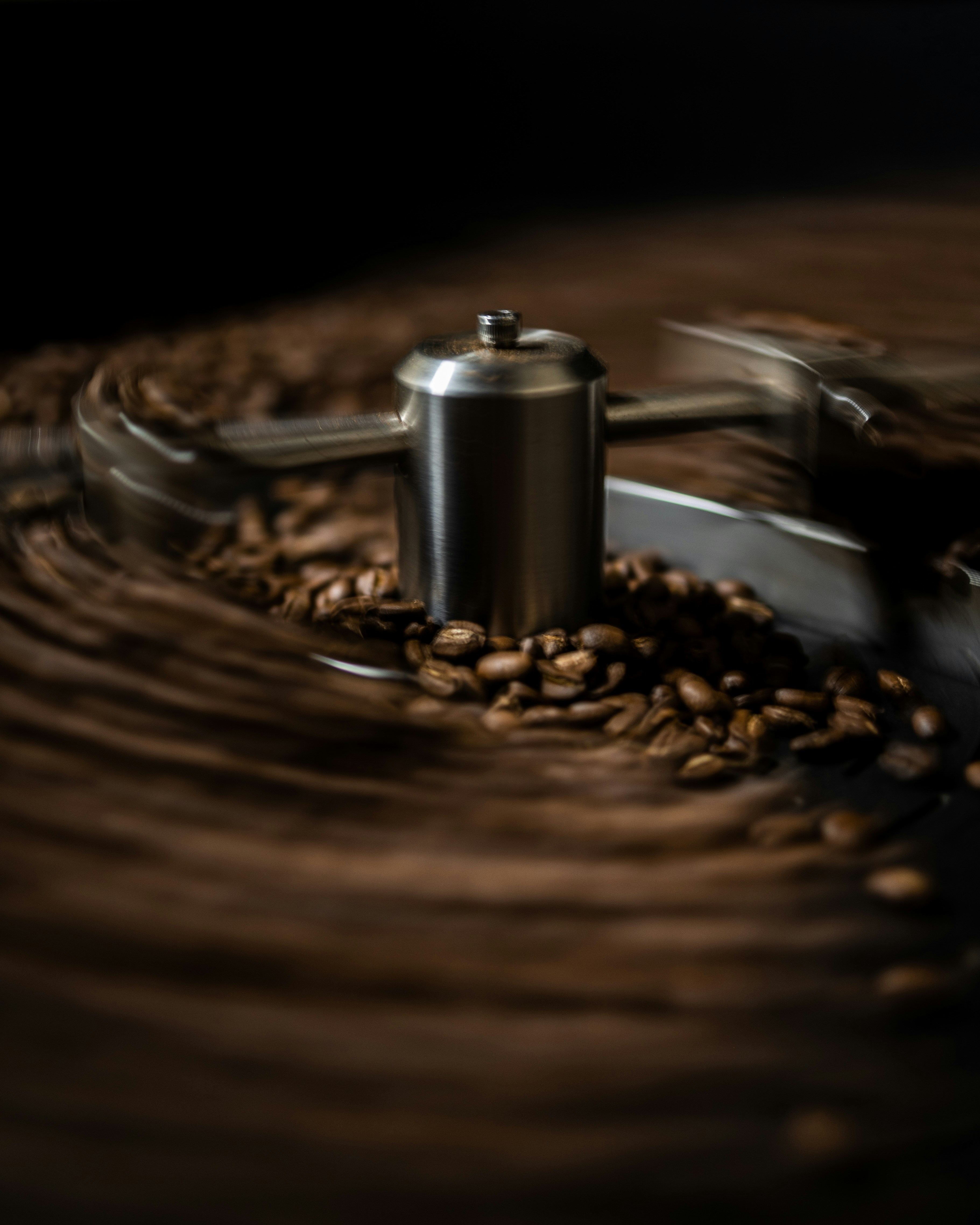 a close-up of a metal object with coffee beans