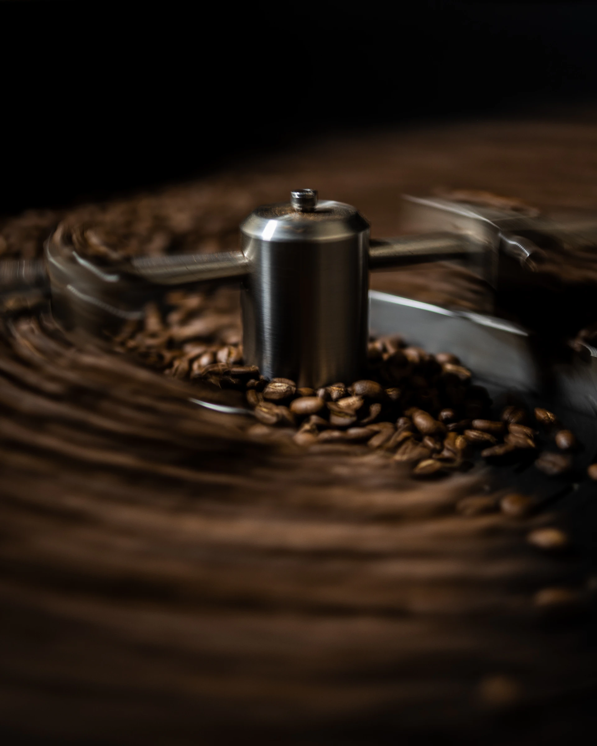 a close-up of a metal object with coffee beans