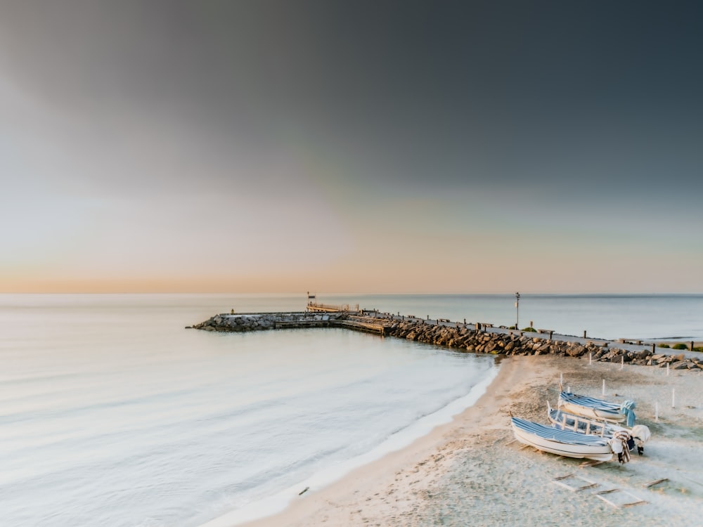 a beach with a pier and boats