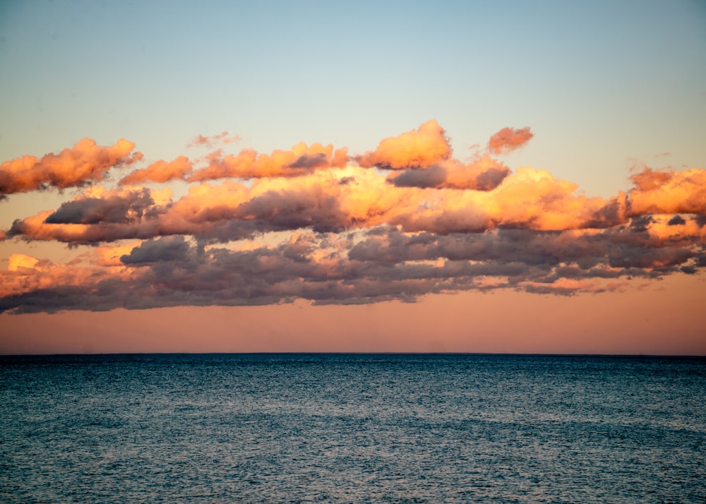 un cuerpo de agua con nubes sobre él