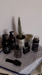 A selection of premium essentials including candles and grooming items arranged on a black velvet cloth with gold ornamental accents.