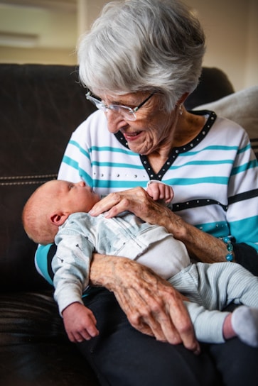 an older woman holding a baby