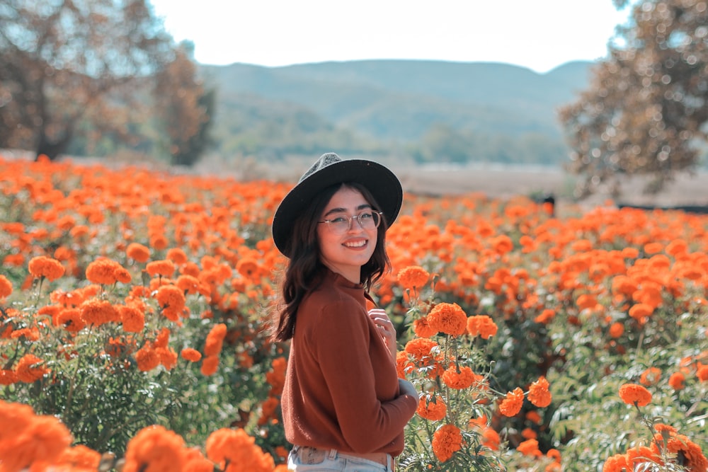 a woman standing in a field of orange flowers