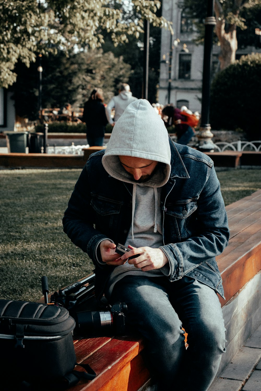 a person sitting on a bench looking at the phone