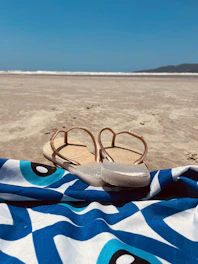 Close-up of adult Havaianas in vibrant colors laid out on a beach towel