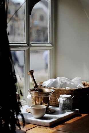 A cozy kitchen scene with jars of dried herbs and a mortar and pestle ready for blending.