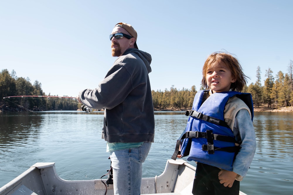 a person and a girl on a boat in a lake