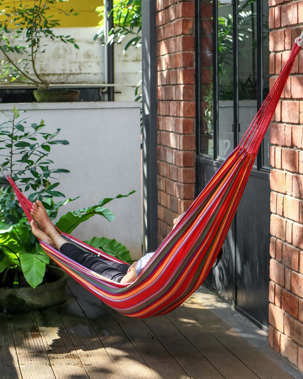 a person lying on a hammock outside